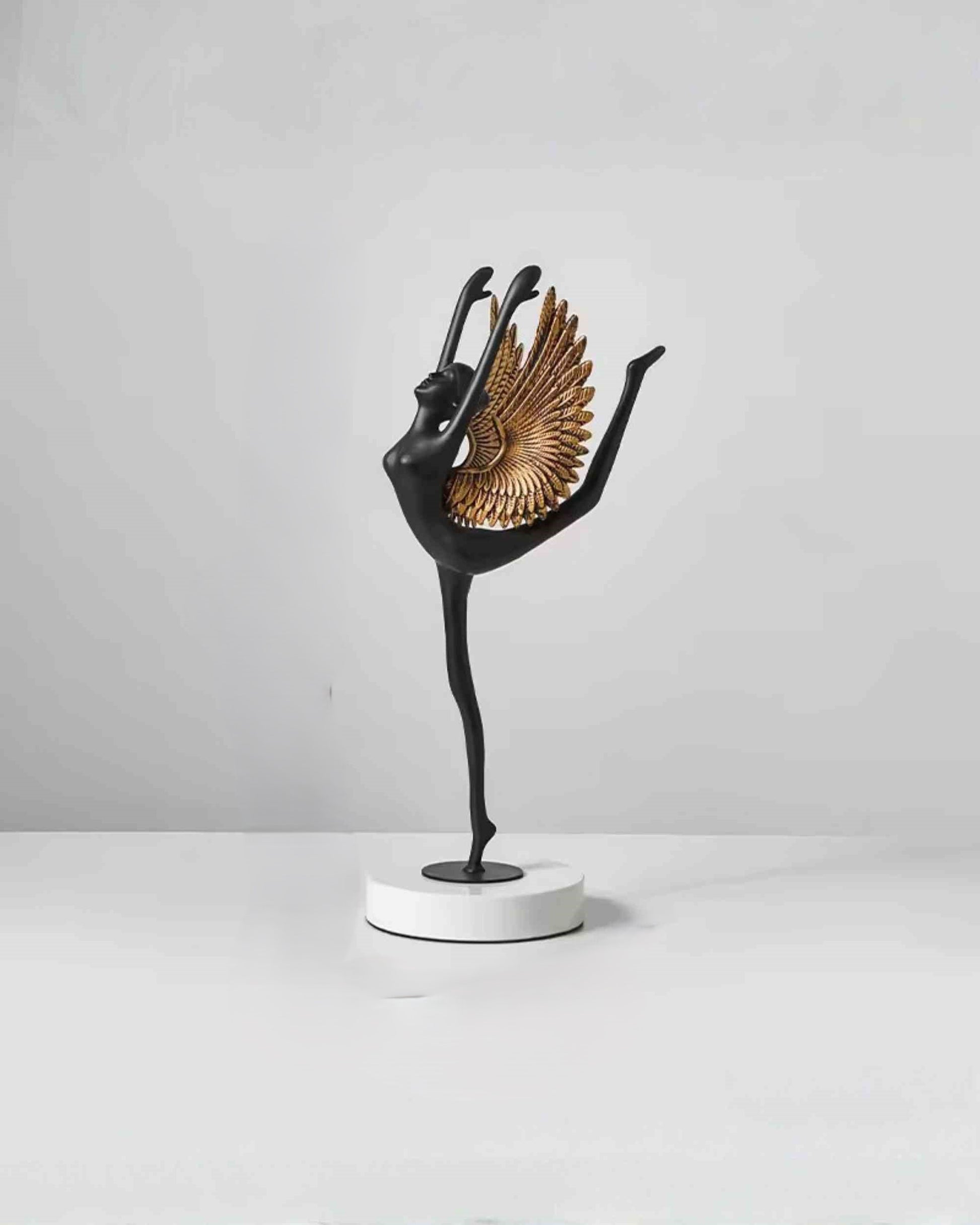 Winged grace sculpture, black standing bird with gold wings, on round white base