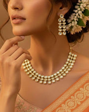 Gold and ivory kundan-style collar necklace with layered pearl-like discs and chain