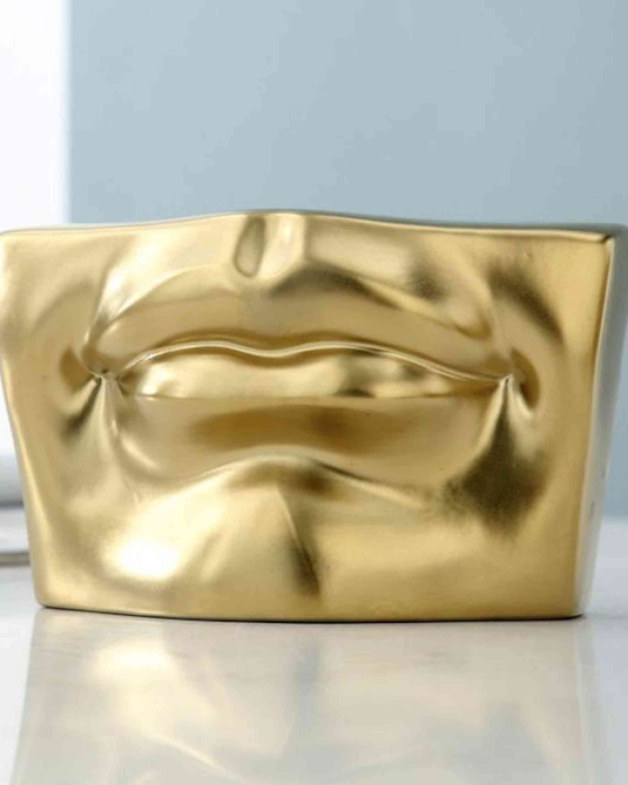 Gold resin sculptural block with embossed facial profile relief, wide rectangle