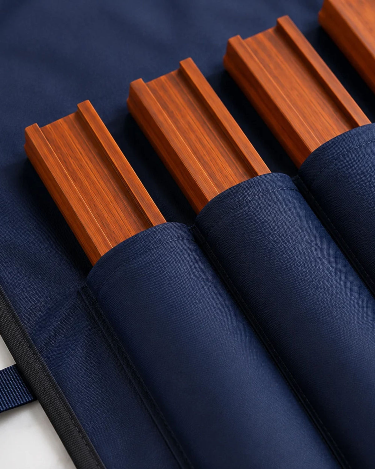 Dark blue storage cover with elastic pockets holding wooden mahjong rack bars