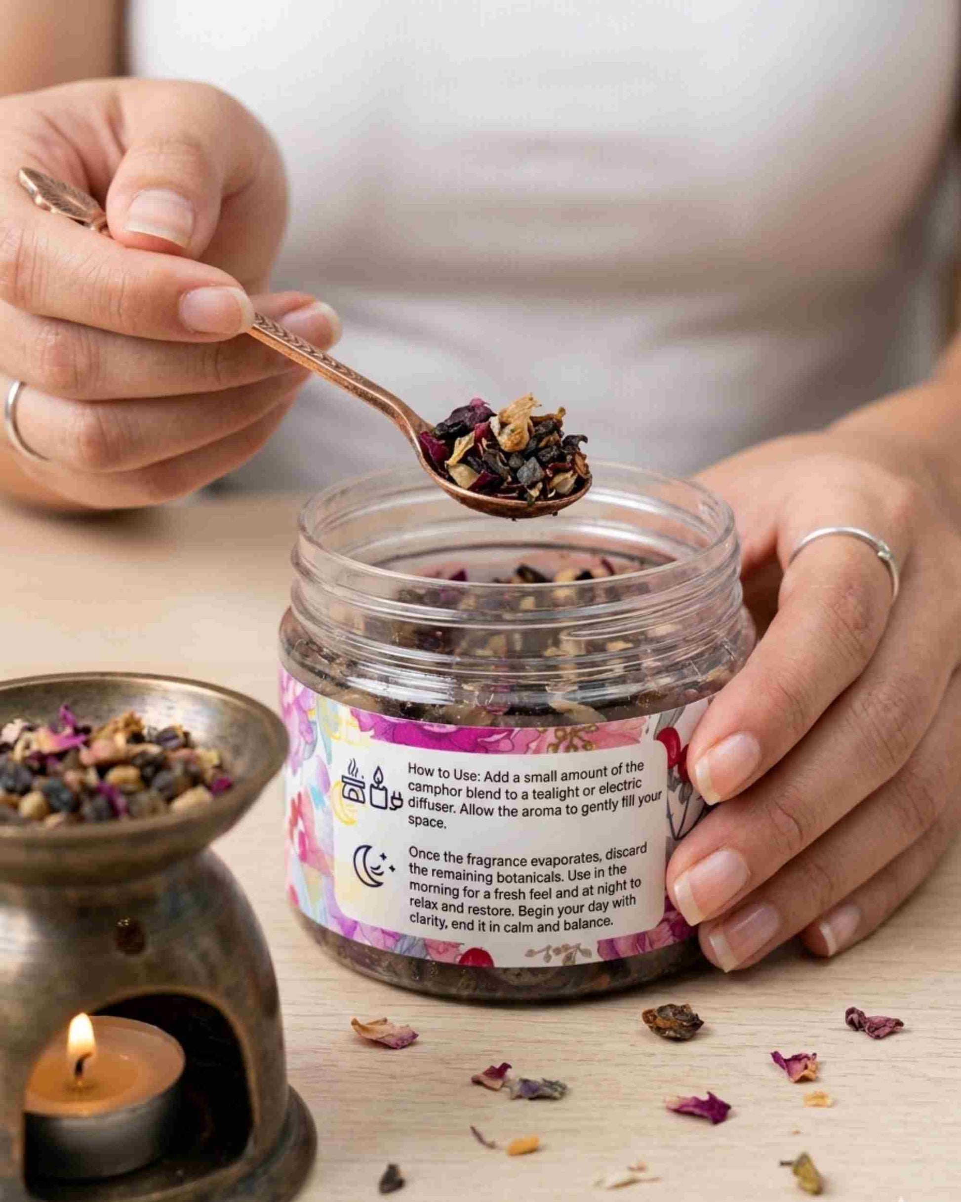 Rose camphor fragrance jar with spoon holding dried flower and camphor blend