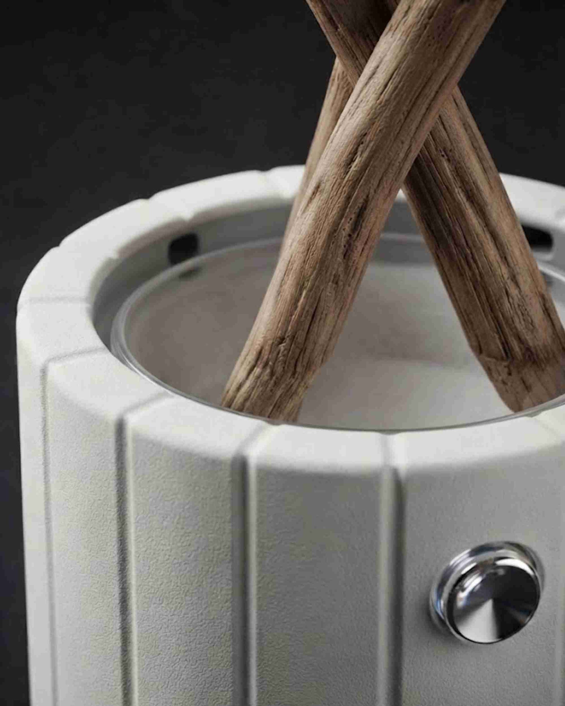 Close-up of white ceramic aroma diffuser showing stacked wood logs and silver knob