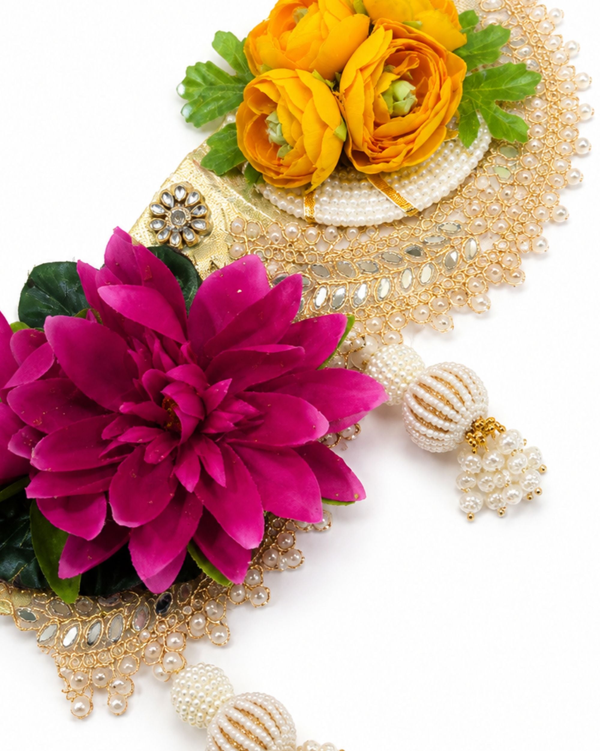 Floral toran close-up with yellow rose, magenta flower, pearl bead strands and gold accents