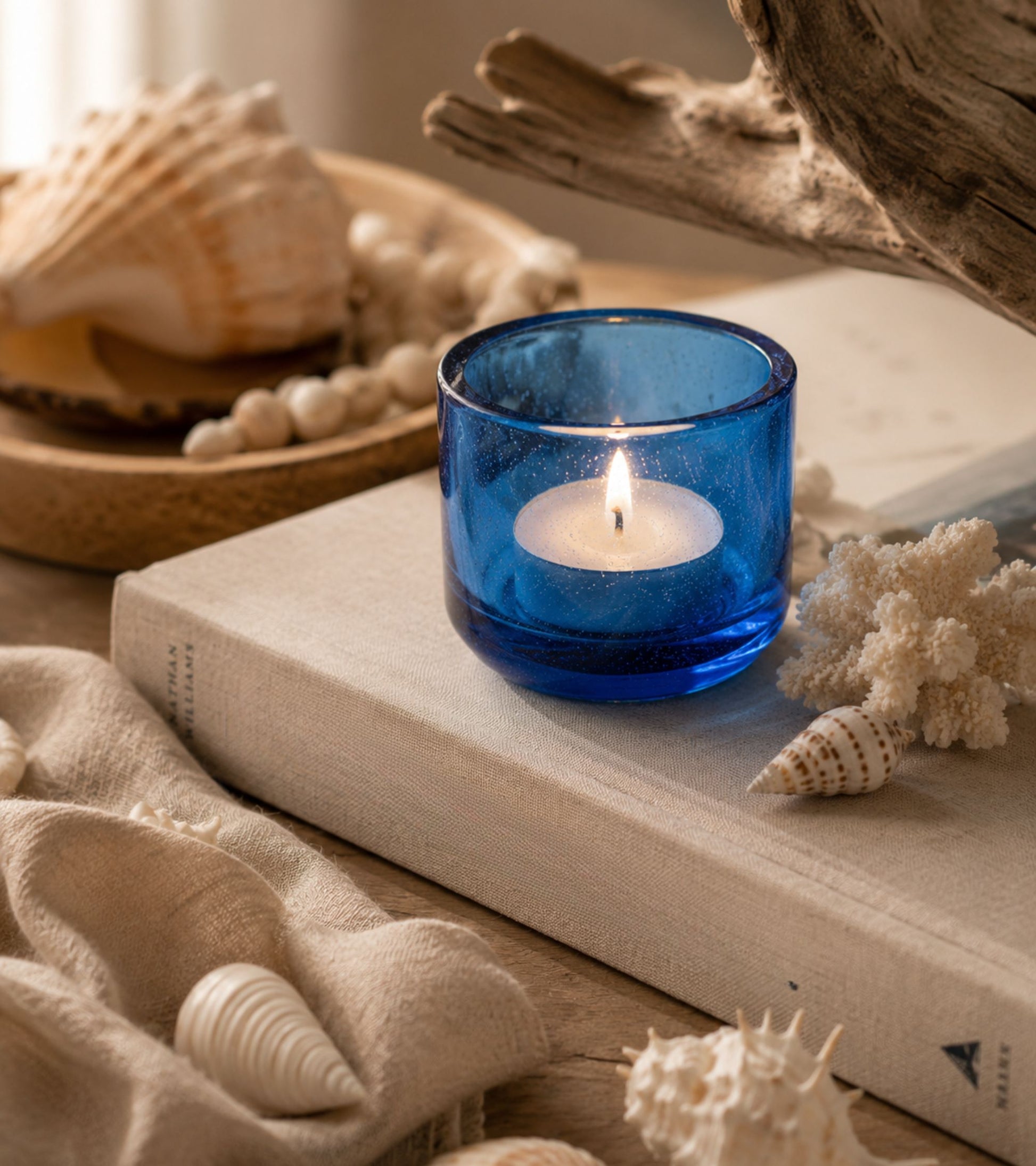 Blue glass votive candle holder with an inserted lit tea light