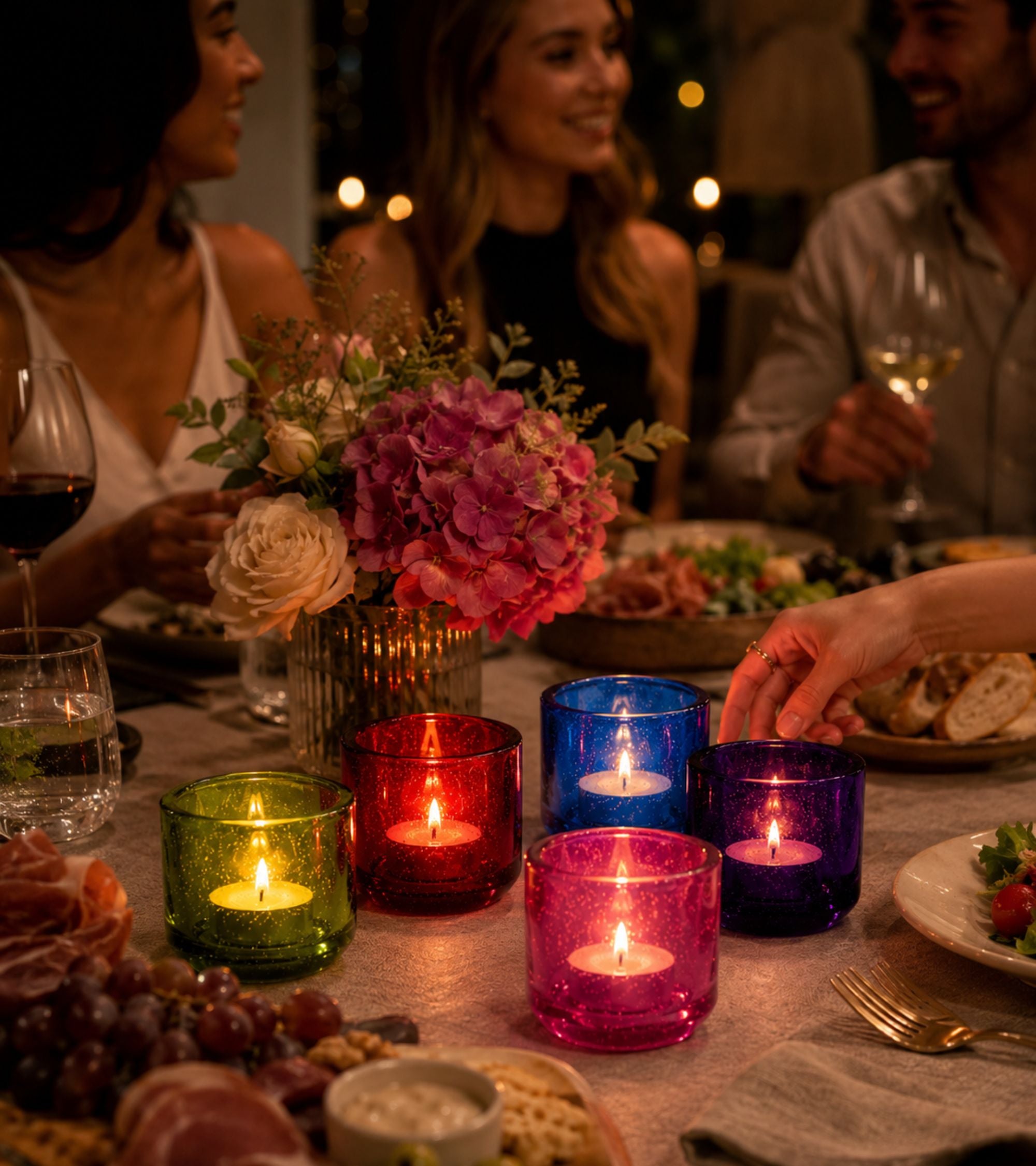 Glass votive candle holders with lit tealights in assorted colors