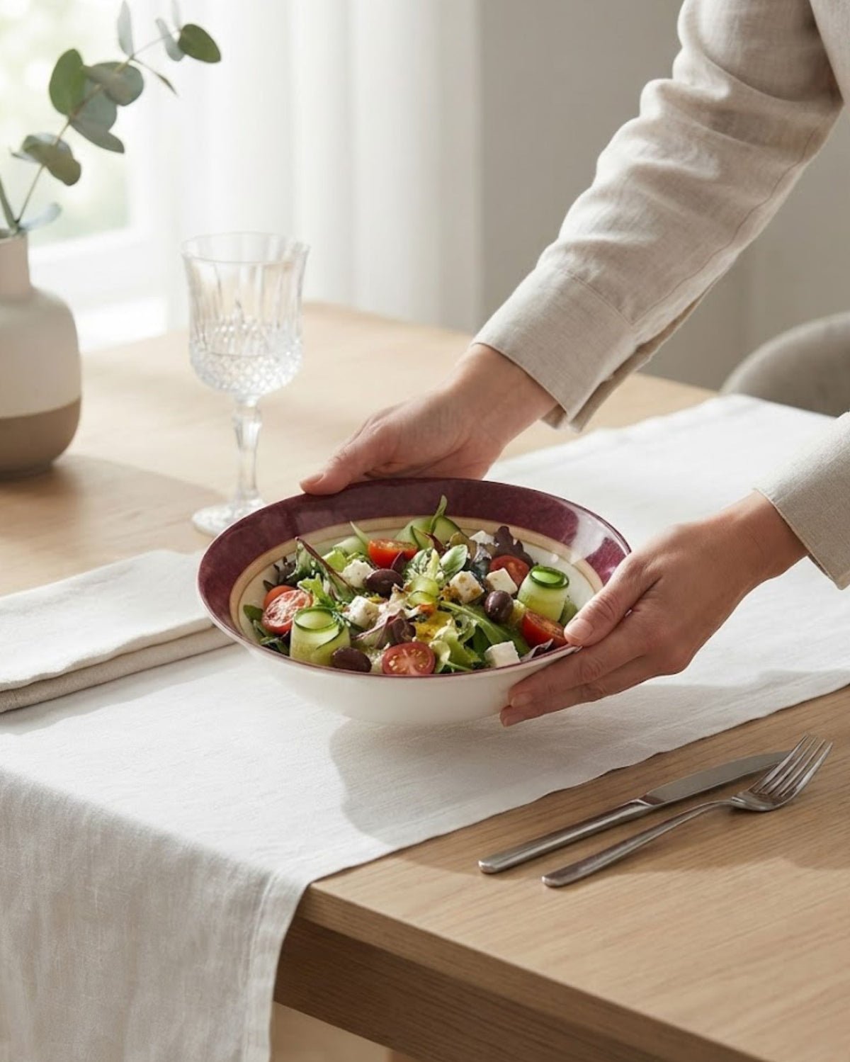 Maroon-rim floral serving bowl holding mixed salad on dining table