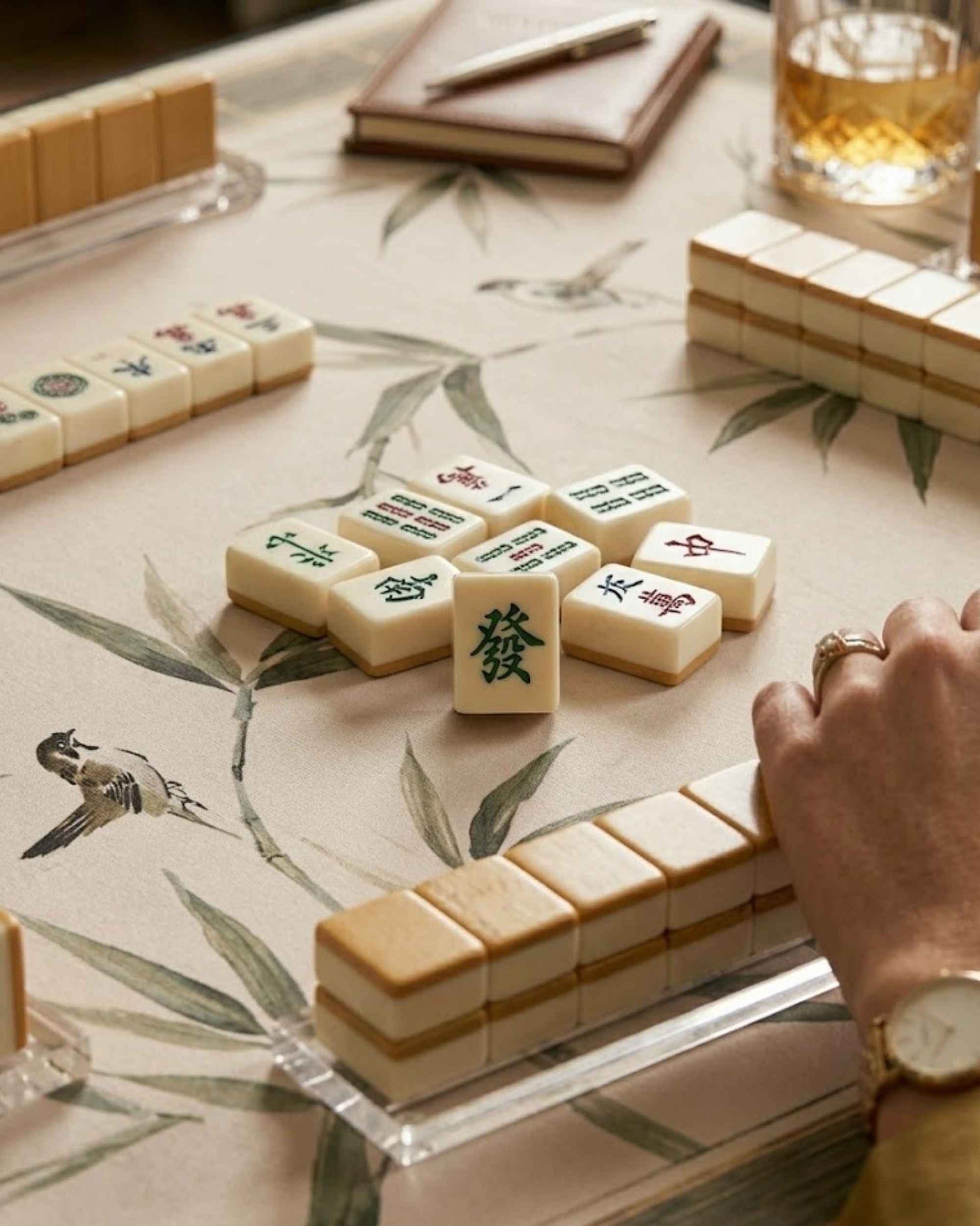 Close-up of cream bamboo-leaf mat with Mahjong tiles scattered near the edges