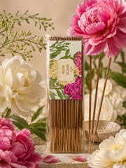 Agarbatti incense sticks in floral box beside standing wooden sticks with pink and white flowers