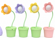 Set of flower LED desk lamps with colored petals and white-glowing bulb in planters
