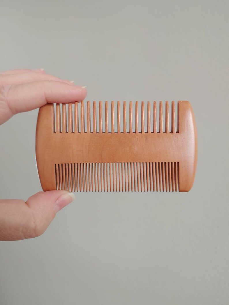 Double-sided wooden hair comb with fine and wide teeth, close-up