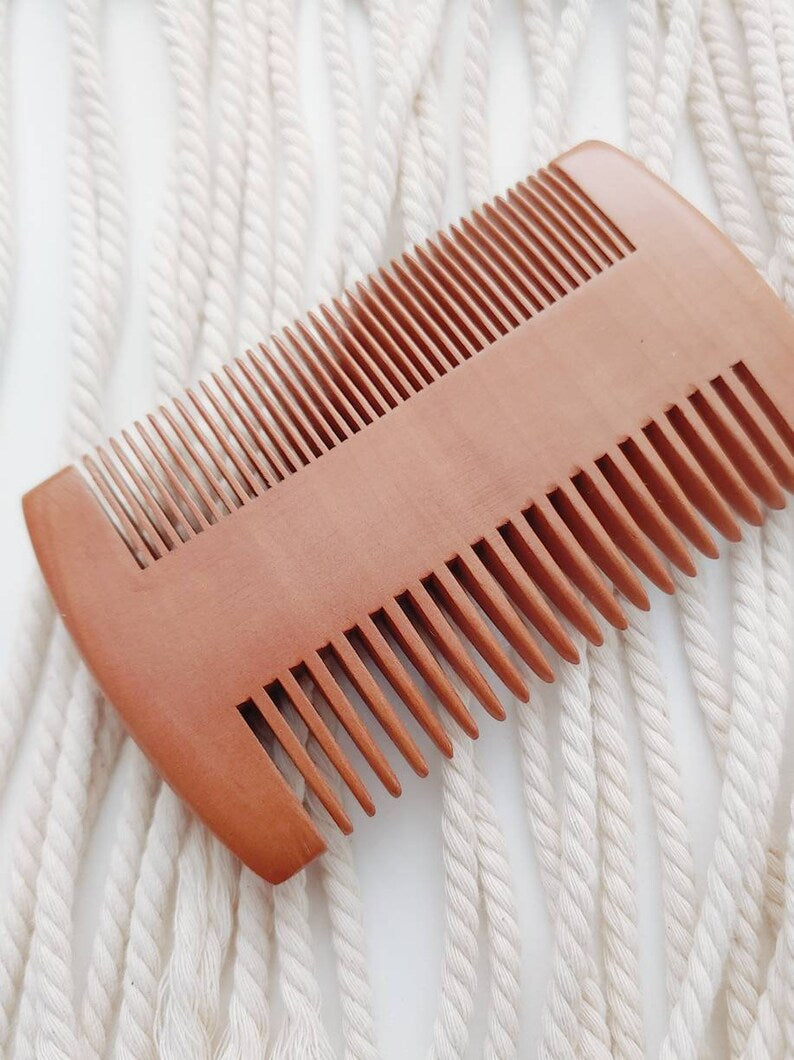 Double-sided wooden hair comb with fine and wide teeth, diagonal view
