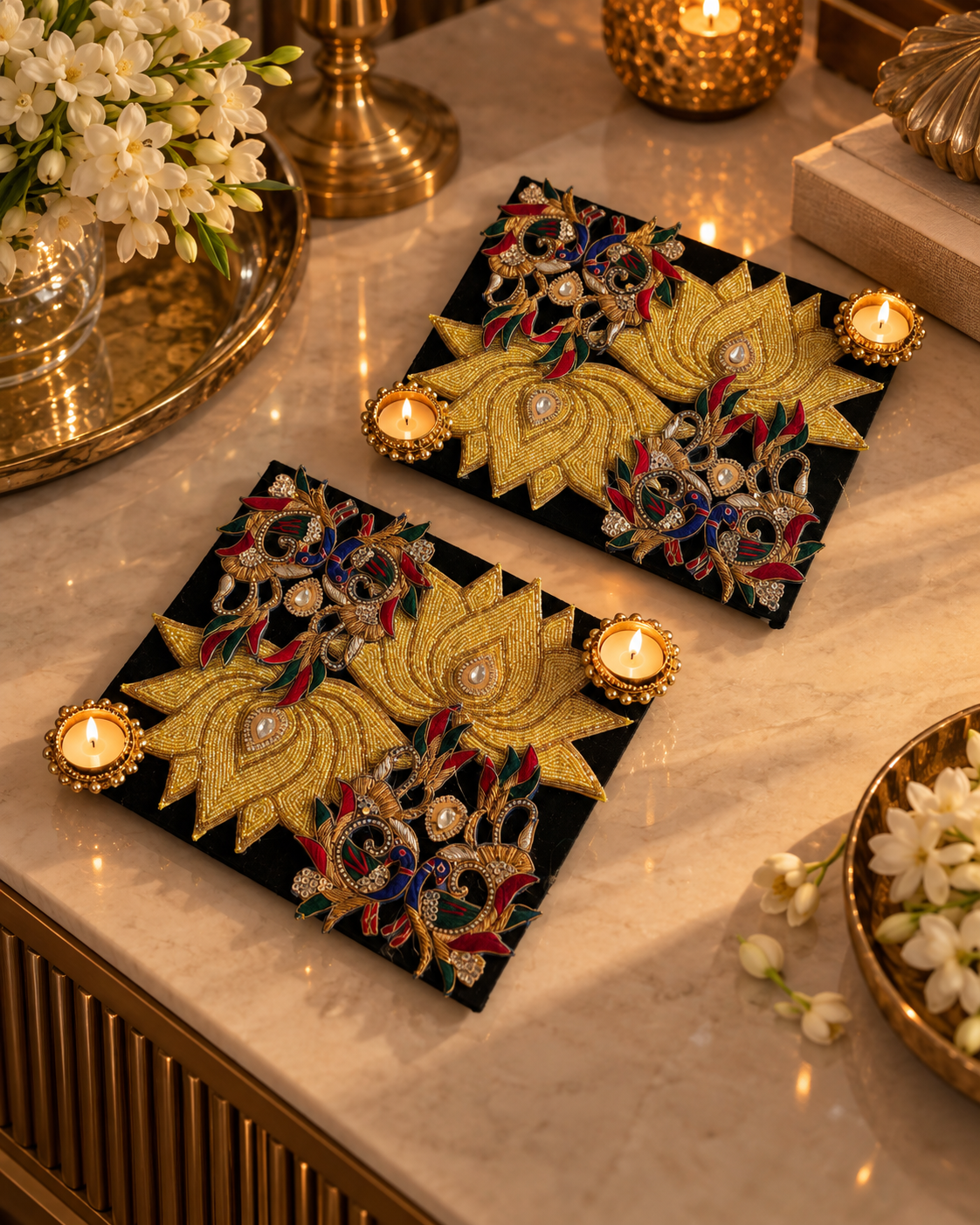 Set of two black and gold peacock lotus tealight candle holders styled on a marble console